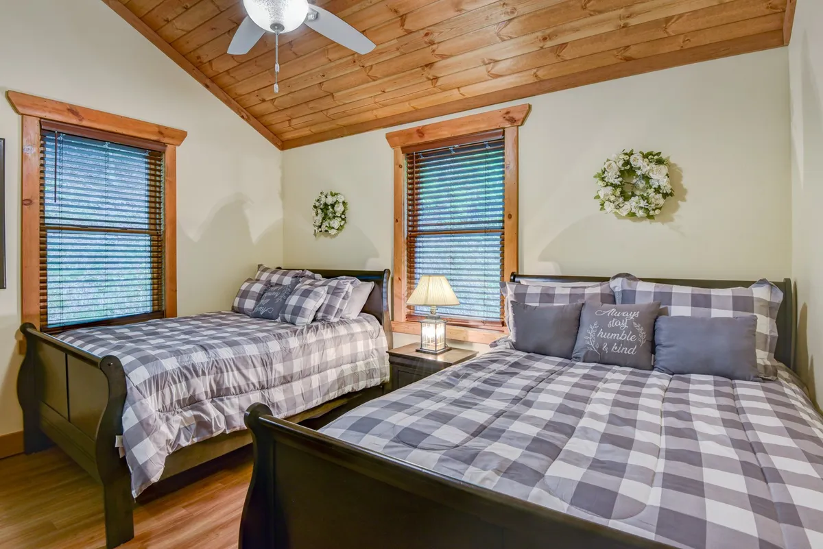 A bright loft area featuring bunk beds, playful wall art, and a small table lamp. The space exudes warmth and is designed for flexibility, appealing to families and children seeking their own retreat.